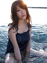Busty asian beauty posing in a skimpy bikini at the beach